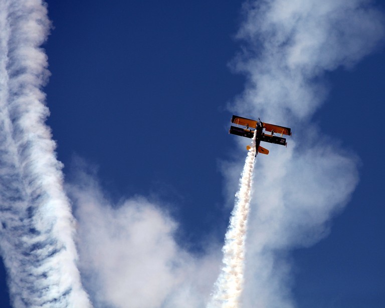 Al Ain Airshow Abu Dhabi plane with smoke in a blue sky