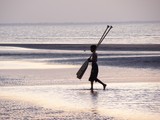 Garçon sur la plage enfant portant des rames au soleil couchant Daymaniyat Islands Nature Reserve - Mascate - Oman
